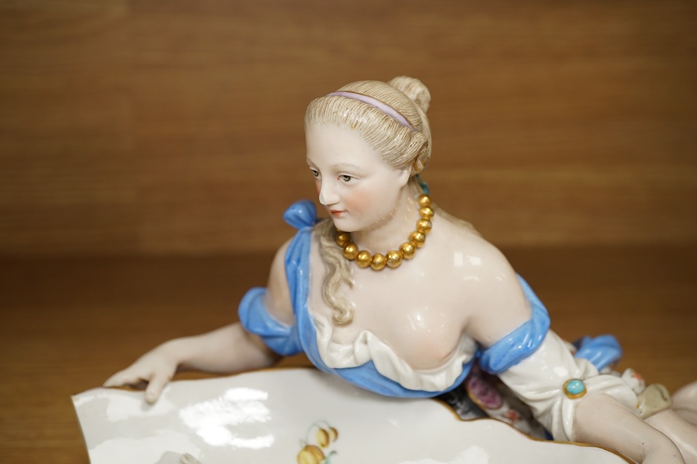 A Meissen female figural dish, 27cm wide. Condition - dish damaged (pieces in bag), crack near front knee